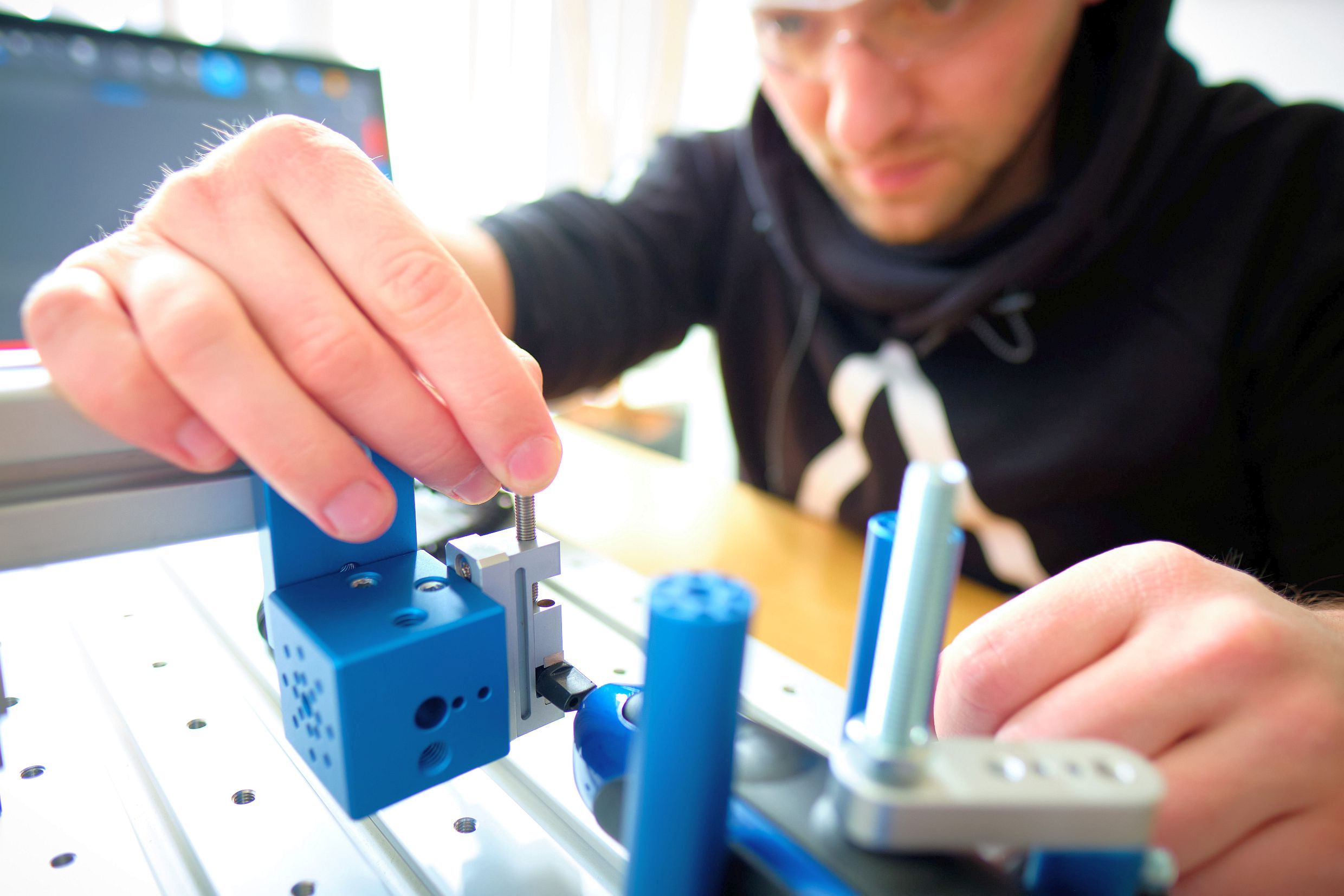 Mitarbeiter baut eine Produktprüfung auf einer Aufspannplatte mit SMARTTESTER® MECHANICS auf